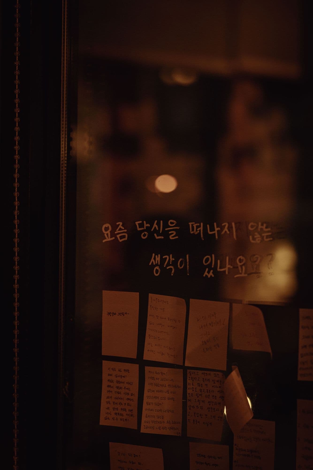 유리창에 손글씨로 적힌 질문과 손님들이 남긴 메모 카드
